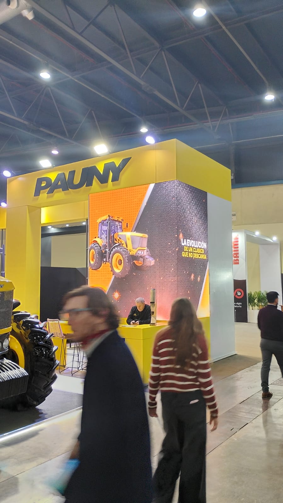 Écran LED en angle présentant des machines dans un stand.