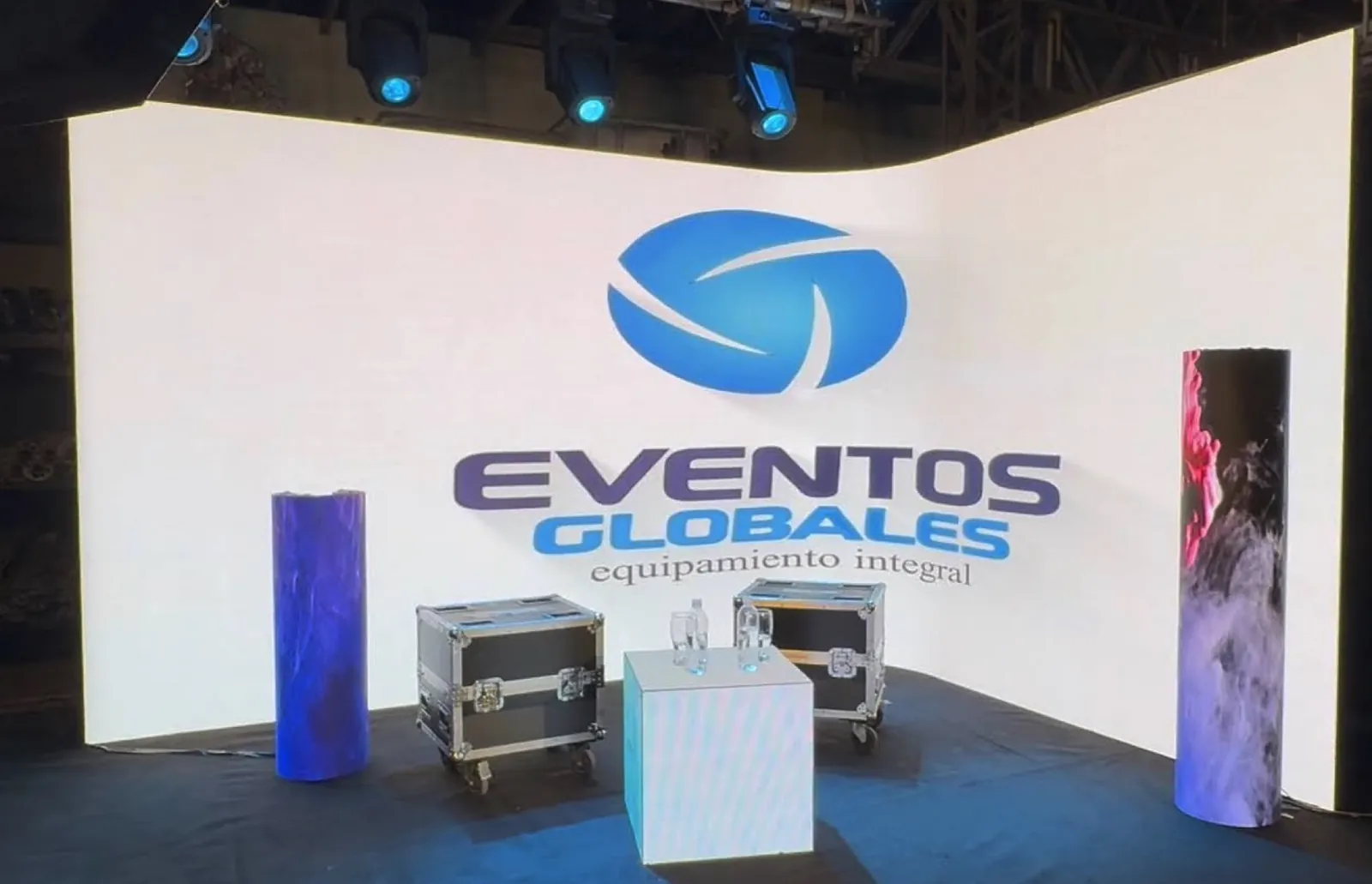Cubo y columnas LED frente a una pantalla curva