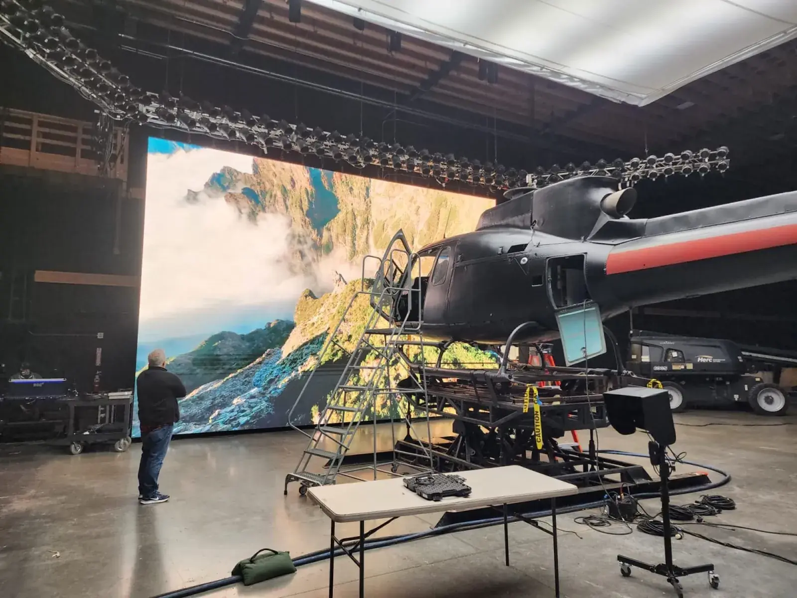 Plateau avec écran LED, éclairage et fuselage d’hélicoptère au premier plan